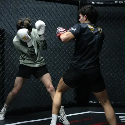 Sparring de boxe avec casques dans la cage du Summa Training Center