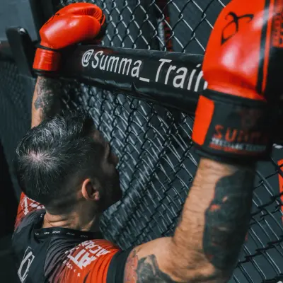 Gants de boxe posés sur la cage MMA du Summa Training Center