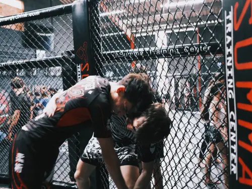 Adolescents en lutte contre la cage pendant le cours MMA du Summa Training Center